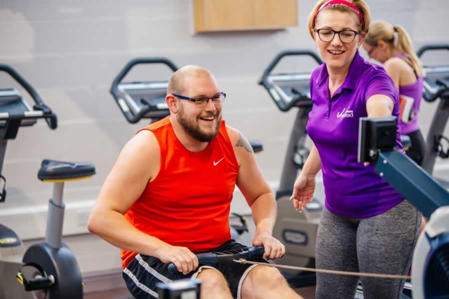 Adult In The Gym Talking To A Fitness Instructor