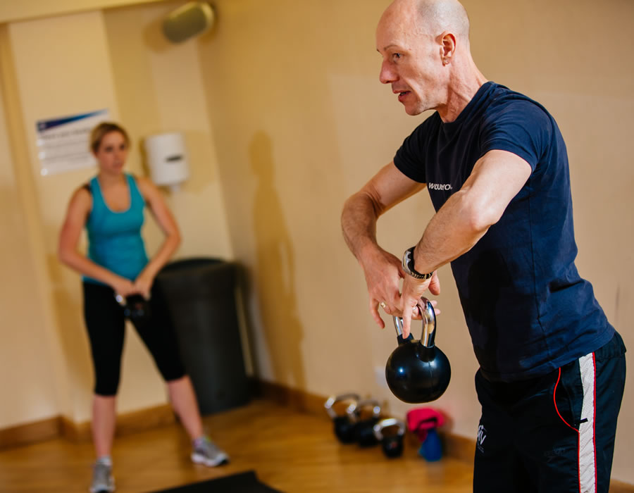 Fitness Instructor Teaching A Kettlebell Fitness Class